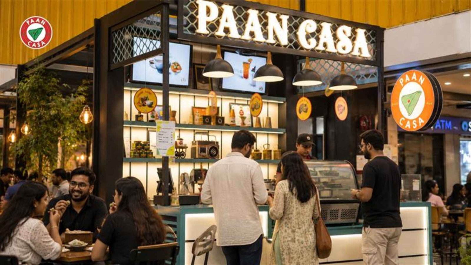 Busy Paan Casa cafe counter with customers ordering paan and enjoying food in a mall setting.